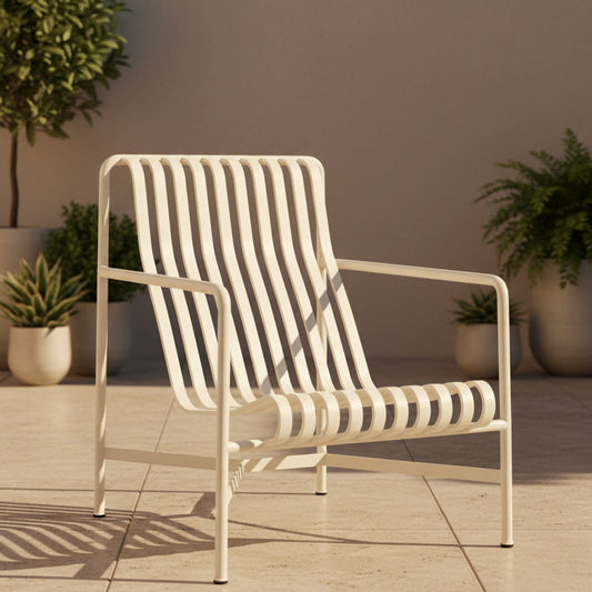A modern white metal armchair with a slatted back and seat, shown from a three-quarter angle against a light gray studio background.