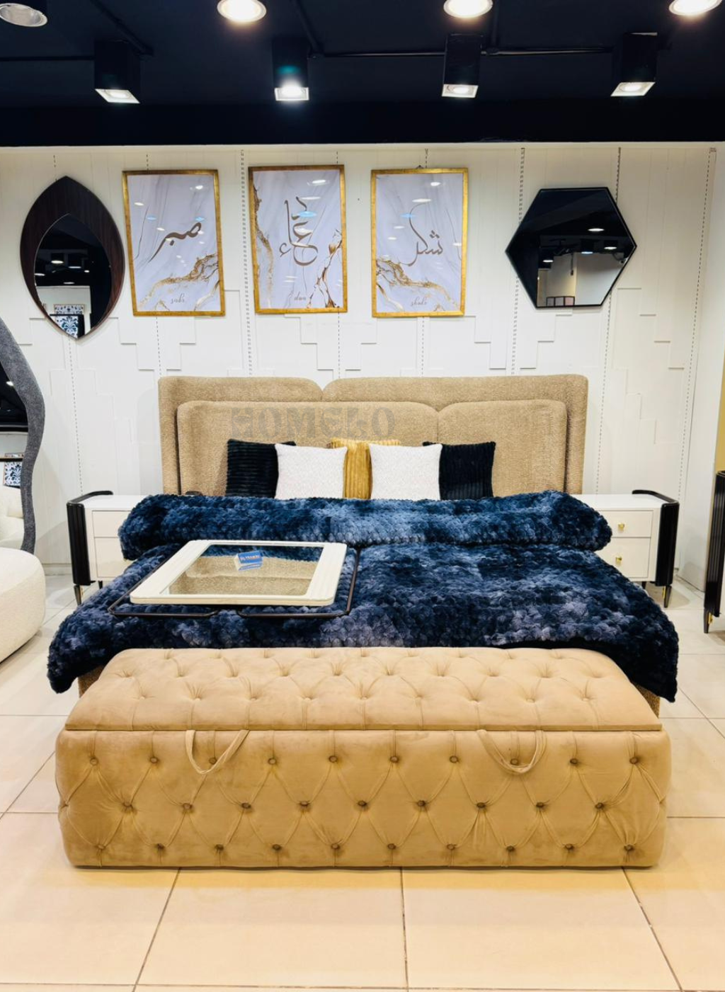 Luxury boucle upholstered bed with wide padded headboard and matching modern side tables in a contemporary bedroom setting.