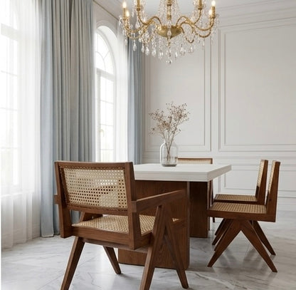 Dining room with wooden chairs and a table, featuring a chandelier and large windows.
