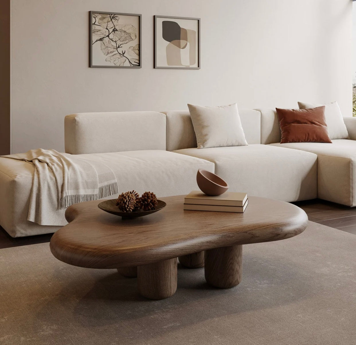 Modern wooden cloud-shaped coffee table with a smooth matte finish and rounded legs on a neutral rug. Overhead view of a minimalist  cloud-shaped coffee table featuring a smooth, organic curved edge and sturdy cylindrical wooden legs, placed in a bright living room