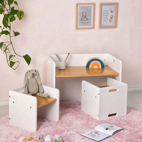 Children's desk with chair and storage box in a room with pink walls and toys on the floor.